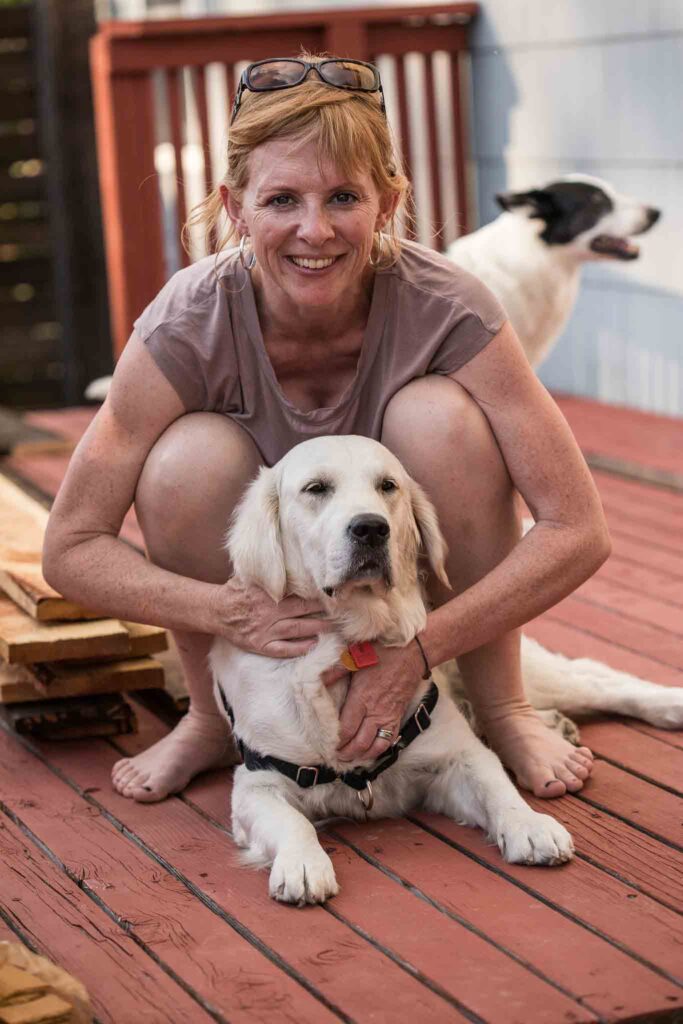 A woman holding a white fur dog